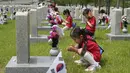 <p>Murid-murid taman kanak-kanak berdoa di depan nisan tentara yang gugur selama Perang Korea 1950-1953 pada malam Memorial Day Korea Selatan di Pemakaman Nasional, Seoul, Korea Selatan, Senin (5/6/2023). Memorial Day di Korea Selatan diperingati setiap tanggal 6 Juni tiap tahunnya. (AP Photo/Ahn Young-joon)</p>