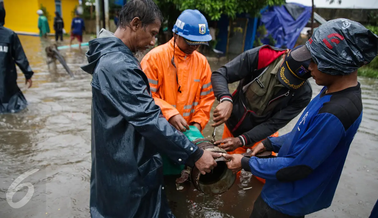 Petugas dari Suku Dinas Tata Air bersiap melakukan penyedotan air banjir yang merendam Jalan Gunung Sahari, Jakarta, Selasa (21/2). Hujan yang mengguyur sejak Selasa dinihari membuat sebagian wilayah di Jakarta banjir. (Liputan6.com/Faizal Fanani)