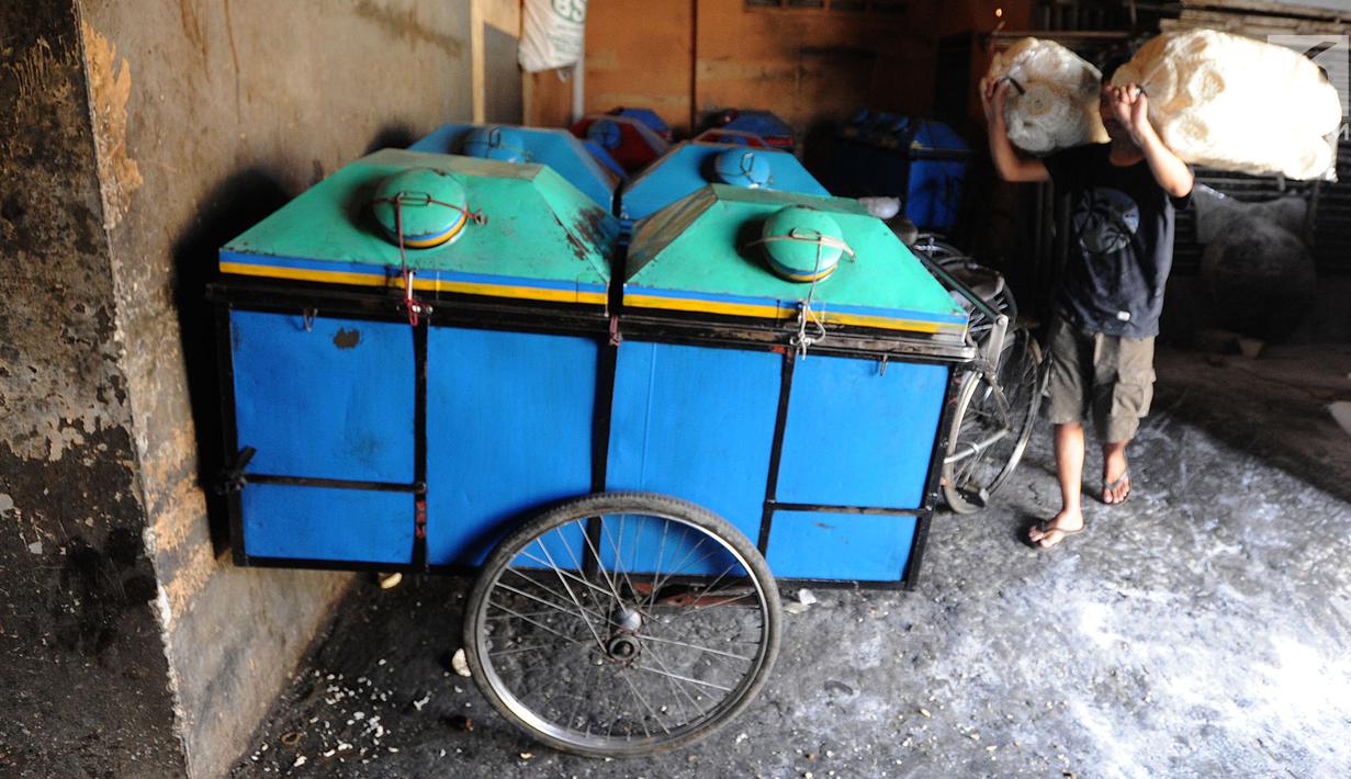 Pekerja memasukan kerupuk kaleng ke dalam gerobak di industri UMKM Nineung di Tangsel, Banten, Jumat (21/6/2019). Kenaikan harga tepung tapioka yang mencapai lebih dari seratus persen semenjak beberapa bulan terakhir menyebabkan produsen kerupuk mengurangi kualitas kerupuk. (merdeka.com/Arie Basuki)