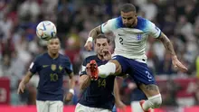 Pemain Timnas Inggris, Kyle Walker menyapu bola dari ancaman pemain Timnas Prancis, Adrien Rabiot dalam laga babak perempatfinal Piala Dunia 2022 di Al Bayt Stadium, Al Khor, Qatar, Minggu (11/12/2022) dini hari WIB. (AP/Frank Augstein)