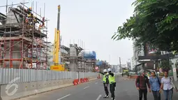 Petugas tampak mengamankan kondisi jalan di sekitar area pemasangan tiang pancang kereta cepat massal di kawasan Blok M, Jakarta, Selasa (30/6/2015). Tiang pancang ini rencananya akan terintegrasi langsung ke Blok M Plaza. (Liputan6.com/Herman Zakharia)