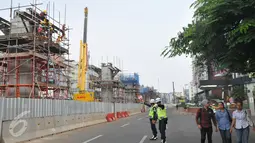 Petugas tampak mengamankan kondisi jalan di sekitar area pemasangan tiang pancang kereta cepat massal di kawasan Blok M, Jakarta, Selasa (30/6/2015). Tiang pancang ini rencananya akan terintegrasi langsung ke Blok M Plaza. (Liputan6.com/Herman Zakharia)