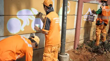 Petugas Penanganan Prasarana dan Sarana Umum (PPSU) membuat mural bertema Asian Games 2018 di kawasan Cawang, Jakarta, Selasa (17/7). Mural tersebut untuk menyambut dan memeriahkan Asian Games 2018 pada Agustus mendatang. (Liputan6.com/Faizal Fanani)