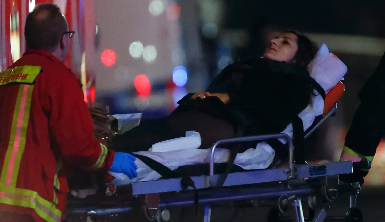 Petugas medis mengevakuasi korban terluka akibat sebuah truk menabrak kerumunan orang di sebuah pasar Natal di pusat Kota Berlin, Jerman, Senin (19/12). Pengemudi truk dilaporkan menerobos pasar Natal yang sedang ramai-ramainya. (REUTERS/Fabrizio Bensch)