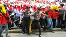 Personel kepolisian berusaha menahan para bidan desa yang berupaya menutup akses jalan saat demonstrasi di depan gedung Kemenkes, Jakarta, Rabu (4/5). Para bidan menuntut diangkat menjadi pegawai tetap tanpa syarat.  (Liputan6.com/Yoppy Renato)