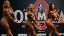 Para peserta wanita memamerkan ototnya saat berpartisipasi dalam kompetisi binaraga Mr. Olympia South America di Medellin, Kolombia (18/2). (AFP Photo / Raul Arboleda)