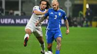 Gelandang Prancis #19, Matteo Guendouzi (kiri), berebut bola dengan bek Italia #03, Federico Dimarco, selama pertandingan Grup A2 Nations League antara Italia dan Prancis di stadion San Siro di Milan, Senin dini hari WIB (18/11/2024). (Alberto PIZZOLI/AFP)