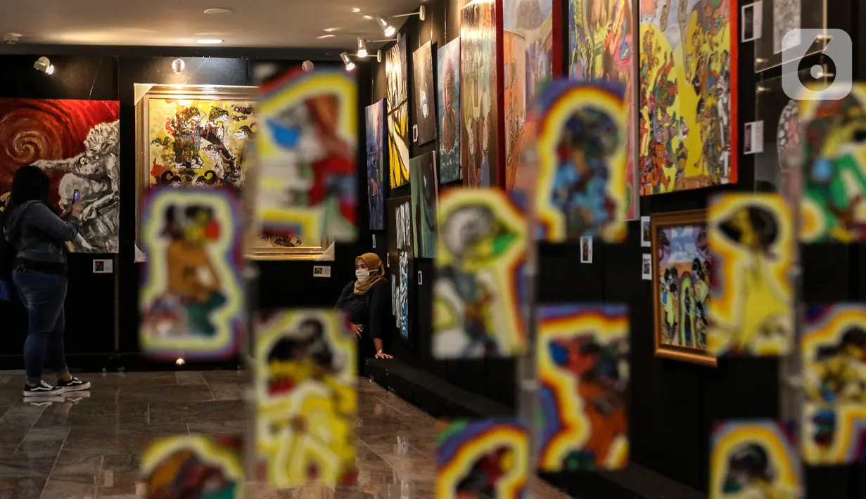 Pengunjung mengamati pameran seni rupa yang bertajuk 'Creative Freedom to Heal The Nation' di Perpustakaan Nasional, Jakarta, Kamis (15/10/2020). Pameran tersebut menceritakan refleksi kehidupan sehari-hari para seniman selama masa Pandemi COVID-19. (Liputan6.com/Johan Tallo)
