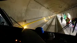 Jurnalis berdiri di atas platform terowongan NEAT Gotthard di Erstfeld, Pegunungan Alpen, Swiss (10/3). Terowongan ini memiliki panjang 57 km yang terdiri dari dua lajur paralel. (REUTERS/Arnd Wiegmann)