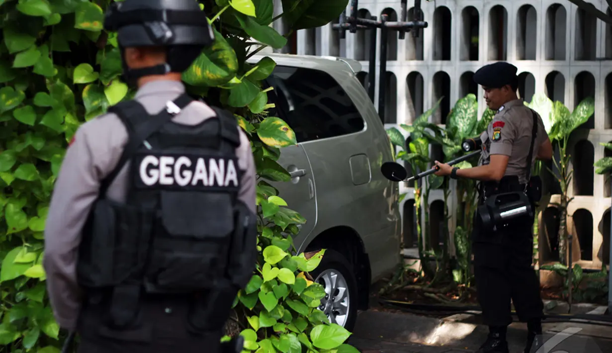 Personel Gegana Polda Metro Jaya memeriksa Sebuah mobil yang terparkir di area gereja katedral, Jakarta, Rabu (24/12/2014). (Liputan6.com/Faizal Fanani)