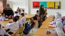 Sejumlah orangtua siswa tampak antusias mendampingi anak mereka mengikuti hari pertama sekolah. (Chaideer MAHYUDDIN/AFP)