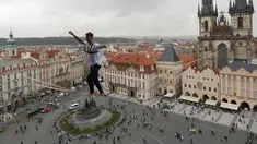 Atlet menyeimbangkan tubuhnya saat berjalan di atas tali yang membentang di Old Town Square, Praha, Republik Ceko, (25/9). Pertunjukan tersebut merupakan bagian kampanye dukungan bagi orang-orang yang hidup dengan diabetes. (AP Photo/Petr David Josek)