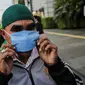 Warga mengenakan masker yang dibagikan relawan di Bundaran HI, Jakarta, Selasa (17/3/2020). Sebanyak 3.000 masker dibagikan gratis kepada pengguna jalan sebagai salah satu bentuk keprihatinan sekaligus berpartisipasi dalam upaya mencegah penyebaran virus corona COVID-19. (Liputan6.com/Faizal Fanani)