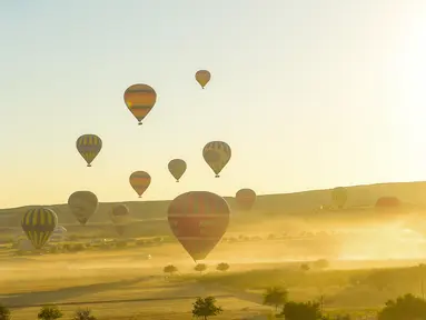 Balon udara panas lepas landas saat akan terbang di atas Nevsehir di wilayah Cappadocia, Turki (5/9). Cappadocia adalah tempat yang unik yang tujuan utama wisatawan yang datang ke Turki. (AFP Photo/Yasin Akgul)