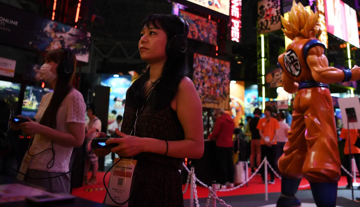 Dua wanita berjalan sambil bermain game selama pameran Tokyo Game Show 2019 di Makuhari, Prefektur Chiba (12/9/2019). Pameran ini diramaikan  1.522 judul game untuk berbagai macam platform. (AFP Photo/Charly Triballeau)