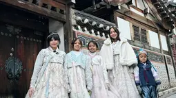 Jalan-jalan di sebuah spot foto menarik dengan latar rumah-rumah zaman dahulu, Ririn dan anak-anak yang tampil kompak mengenakan hanbook ini terlihat keren. Apalagi kedua putri dari Ririn Dwi Ariyanti yang kini sudah tumbuh semakin besar pun terihat menggemaskan. (Liputan6.com/IG/@ririndwiariyanti)