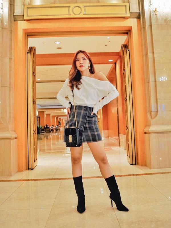 Tampil dengan look yang elegan, wanita yang dulunya berprofesi sebagai reporter ini mengenakan atasan putih yang dipadukan dengan rok bermotif kotak-kotak dan heels hitam. (Liputan6.com/IG/@natyashina)