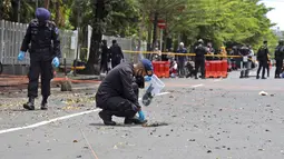 Tim penjinak bom menggeledah area sekitar lokasi serangan bom bunuh diri di Gereja Katedral Makassar, Sulawesi Selatan, Senin (29/3/2021). Kepolisian masih melakukan olah TKP serta mengumpulkan serpihan sisa ledakan pada hari kedua pascaledakan bom bunuh diri di depan gereja itu. (AP/Yusuf Wahil)