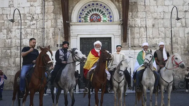 Jemaah haji, termasuk tiga orang dari Spanyol, berpose dengan kuda mereka di luar Pasar al-Hamidiyah di Damaskus, Suriah, 21 April 2025, selama perjalanan berkuda selama berbulan-bulan dari Spanyol ke Arab Saudi untuk melaksanakan ibadah haji.