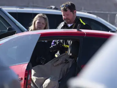 Polisi mengambil foto TKP setelah penembakan di tempat parkir Walmart, Duncan, Oklahoma, Amerika Serikat, Senin (18/11/2019 ). Kejadian tersebut menewaskan tiga orang, termasuk seorang pelaku. (J Pat Carter/Getty Images/AFP)