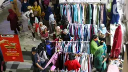 Calon pembeli memilih baju di Pasar Tanah Abang, Jakarta, Sabtu (23/4/2022). Menjelang Lebaran, Pasar Tanah Abang dipadati pengunjung yang memburu busana atau pakaian muslim untuk menyambut Hari Raya Idul Fitri 1443 Hijriah. (Liputan6.com/Herman Zakharia)