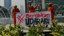 Aktivis membentangkan spanduk saat kampanye damai terkait buruknya udara Jakarta di Bundaran HI, Rabu (5/12). Aksi tersebut sebagai bentuk kekecewaan kepada pemerintah akibat lalai dalam menangani polusi udara di Jakarta. (Merdeka.com/Imam Buhori)