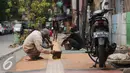 Para pekerja menyelesaikan pembangunan Trotoar Ramah Disabilitas di Jalan Hidup Baru, Kalimati, Jakarta Utara, Selasa (27/12). (Liputan6.com/Gempur M. Surya)