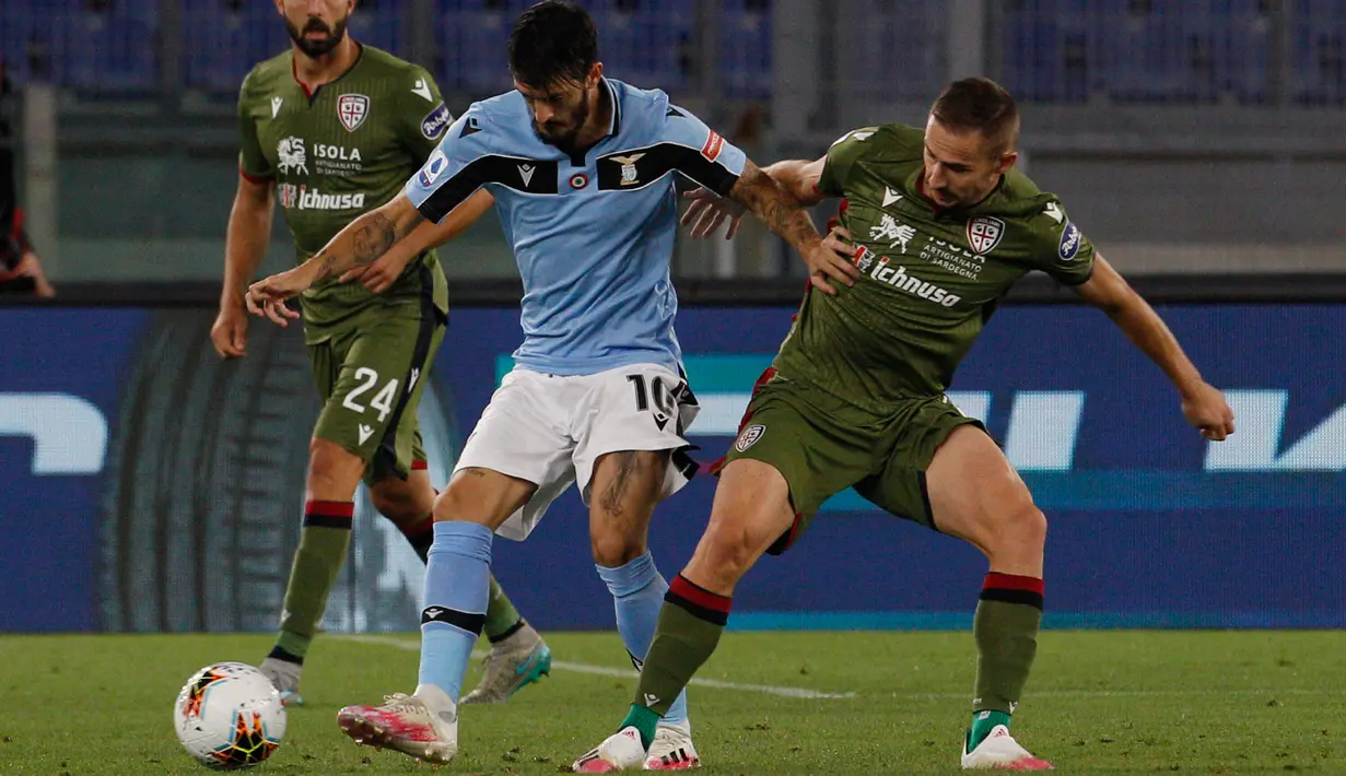Gelandang Lazio, Luis Alberto berusaha membawa bola dari kawalan pemain Cagliari, Marko Rog  pada pertandingan lanjutan Liga Serie A Italia di Stadion Olimpiade Roma, di Roma, Italia, Kamis, (23/7/2020). Lazio menang 2-1 atas Cagliari. (AP Photo/Riccardo De Luca)