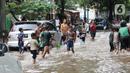 Anak anak bermain air di sebagian Jalan Bungur Besar Raya yang tergenang, Jakarta, Selasa (18/1/2022). Genangan air di sebagian Jalan Bungur Besar Raya dimanfaatkan anak-anak untuk bermain meski berbahaya. (Liputan6.com/Helmi Fithriansyah)