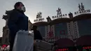 Orang-orang mengenakan masker penutup mulut saat menuju stasiun kereta api Beijing untuk mudik Tahun Baru Imlek pada Selasa (21/1/2020). Wabah virus korona seperti SARS yang menyebar di China dan mencapai tiga negara Asia lainnya bisa menular dari manusia ke manusia. (NICOLAS ASFOURI/AFP)