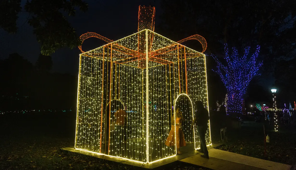 Orang-orang mengunjungi "Trail of Lights" Kebun Raya Durban menjelang Natal di Durban, Afrika Selatan (14/12/2021). Acara ini akan berlangsung mulai 11 Desember dan berlangsung hingga 30 Desember 2020. (AFP/Rajesh Jayantilal)
