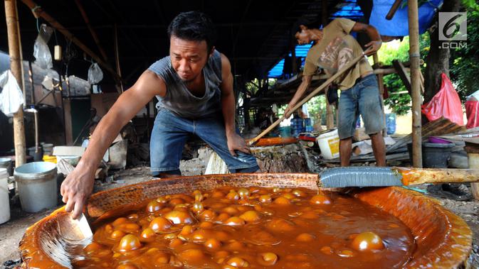 Pekerja membuat dodol Betawi di kawasan Studio Alam TVRI, Cilodong, Depok (31/5). Jelang Lebaran, dalam sehari tempat pembuatan ini dapat menghasilkan 400 kilogram dodol. (Merdeka.com/Arie Basuki)