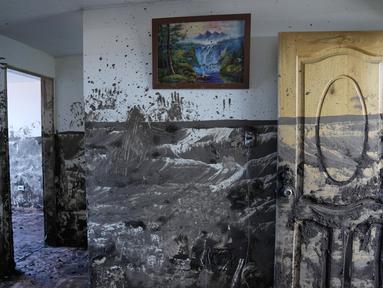 Garis di dinding menandai tingkat lumpur yang dicapai di dalam rumah sehari setelah lereng bukit yang diguyur hujan runtuh dan membawa gelombang lumpur ke rumah-rumah dan lapangan olahraga, di lingkungan La Gasca di Quito, Ekuador, Rabu (2/2/2022). Sedikitnya 24 orang tewas. (AP Photo/Dolores Ochoa)