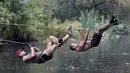 Peserta menyebrangi sungai dengan sebuah tali saat mengikuti kompetisi lari ekstrim di Zhodino, Minsk timur, Belarus, 26 September 2015. (REUTERS/Vasily Fedosenko)