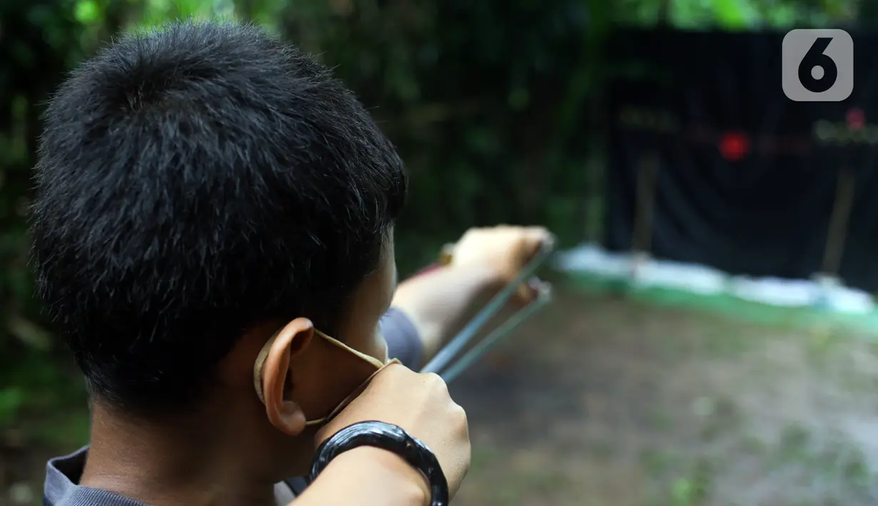 Anak-anak yang tergabung dalam Ketapel Anak Ciliwung (Kancil) bermain ketapel di kawasan Ciliwung Muara Baru, Jakarta, Selasa (9/11/2021). Selain melestarikan permainan tradisional, bermain ketapel dapat melatih kesabaran, konsentrasi dan motorik otak kanan bagi anak. (Liputan6.com/Herman Zakharia)