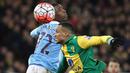 Pemain Manchester City, Kelechi Iheanacho (kiri) berebut bola dengan pemain Norwich City, Martin Olsson pada laga Babak ketiga Piala FA di Stadion Carrow Road, Norwich, Sabtu (9/1/2016). (AFP Photo/Lindsey Parnaby)