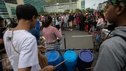 Kreatifitas mahasiswa dalam bermusik dengan alat musik dari barang bekas sangat menghibur warga yang beraktifitas di Car Free Day Bundaran HI, Jakarta, Minggu (15/1). (Liputan6.com/Faizal Fanani)