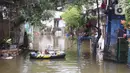 Seorang warga beristirahat di perahu karet saat banjir melanda perumahan Periuk Damai, Tangerang, Banten, Selasa (22/2/2021). Ratusan rumah masih terendam banjir sampai menyentuh ke atap rumahnya. (Liputan6.com/Angga Yuniar)