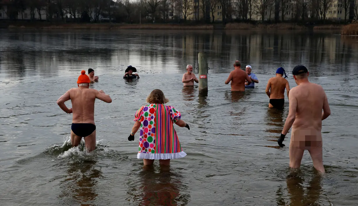 Anggota klub renang es "Berliner Seehunde" berenang di danau Orankesee, sebagai perayaan tahun baru di Berlin, Jerman (1/1). Terlihat kebanyakan dari mereka adalah orang tua berusia lanjut. (REUTERS/Fabrizio Bensch)