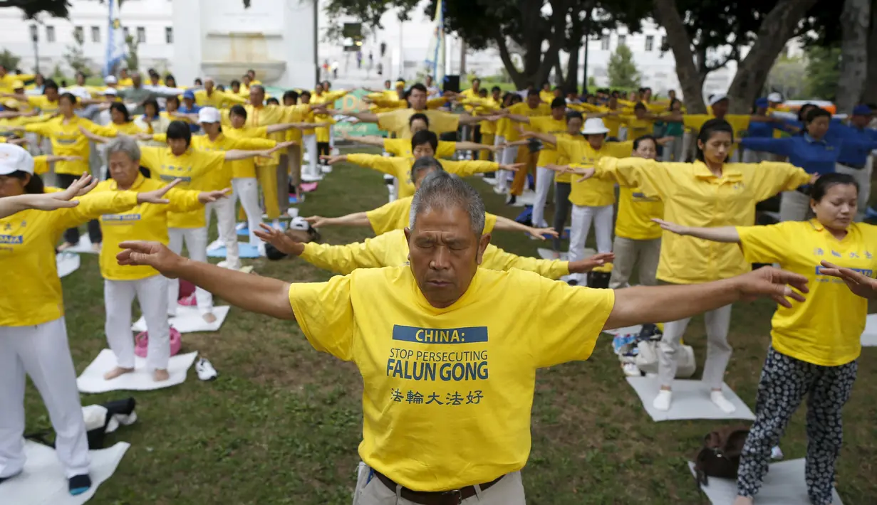 Sekelompok orang saat melakukan meditasi Falun Gong sebelum aksi menentang pemerintah China, di luar Balaikota Los Angeles, California, Kamis (15/10). Presiden China Xi Jinping akan melakukan kunjungan kenegaraan di Washington. (REUTERS/Lucy Nicholson)