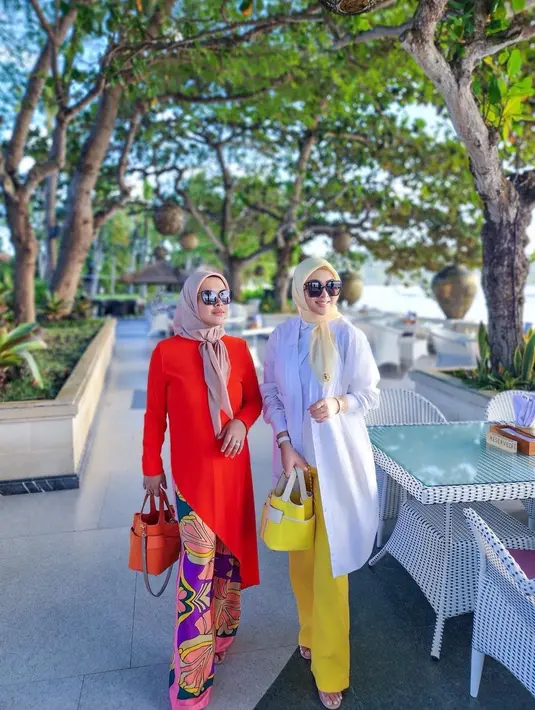 Syahrini tetap tampil mewah saat nikmati keindahan Bali. Ia padukan warna kuning dan putih untuk tampilan yang cerah di pinggir pantai [@princessyahrini]