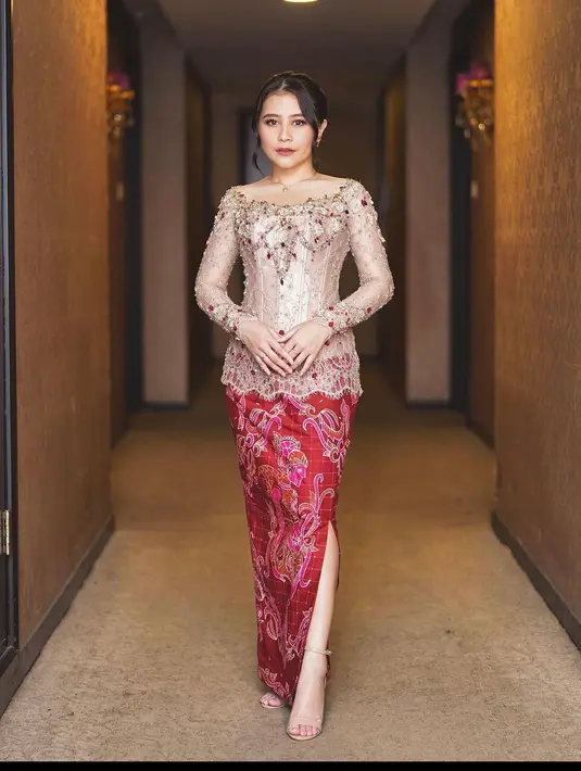 Kebaya bewarna krem dengan detail kerah sabrina dan payet manik manik yang senada dengan warna batik ini sangat anggun ketika dipakai pada acara formal. (instagram/prillylatuconsina96)