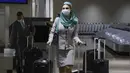 Seorang pramugari yang mengenakan masker pelindung tiba di Bandara Internasional Manila, Filipina, Kamis (10/2/2022). Filipina mulai hari ini membuka kembali pintu bagi turis asing setelah hampir dua tahun menutup perbatasannya. (AP Photo/Basilio Sepe)