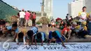 Sejumlah anak menulis di banner yang telah disediakan salah satu perusahaan alat tulis saat memperingati Hari Pelanggan Nasional di Bundaran Hotel Indonesia, Jakarta, Minggu, (6/9/2015). (Liputan6.com/Helmi Afandi) 