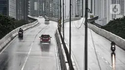 Pengendara sepeda motor (kiri) mengalami mogok saat menerobos Jalan Layang Non Tol (JLNT) Casablanca saat hujan, Jakarta, Minggu (20/12/2020). Aksi nekat para pengendara sepeda motor tersebut dapat mengancam keselamatan diri serta pengguna jalan lain. (merdeka.com/Iqbal S. Nugroho)