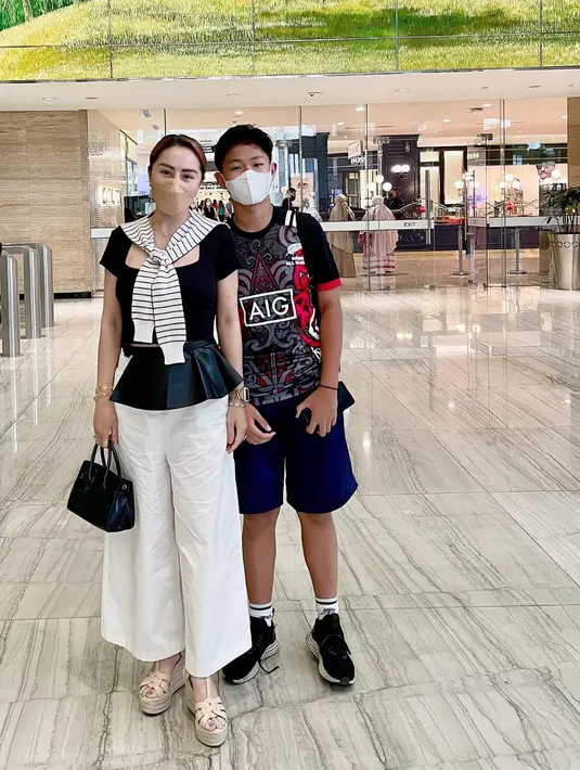 Kali ini dengan putranya Rainier Chang, Femmy Permatasari kembali tampil dengan outfit serasi. Femmy cantik dengan atasan berwarna hitam dan celana panjang putih, sedangkan putranya mengenakan kaus bermotif yang juga berwarna hitam dan celana pendek berwarna biru navy. Foto: Instagram.