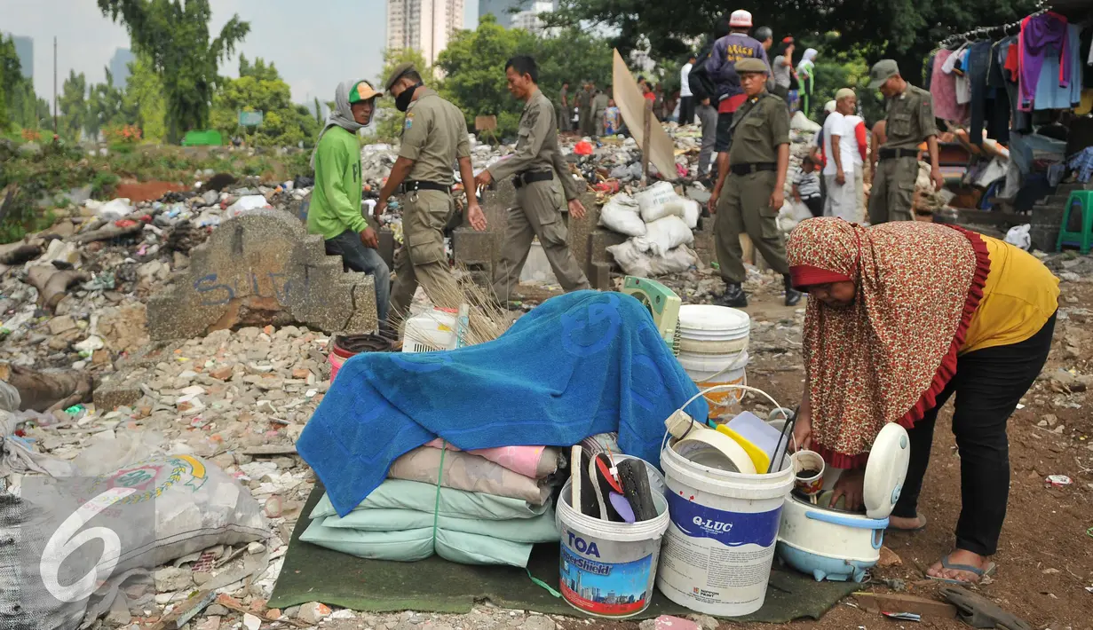 Warga mengumpulkan barang miliknya di kawasan TPU Menteng Pulo, Jakarta Selatan (7/4). Lebih dari seratus kepala keluarga digusur karena mereka menempati lahan dan mendirikan bangunan di tempat pemakaman umum. (Liputan6.com/Gempur M Surya)