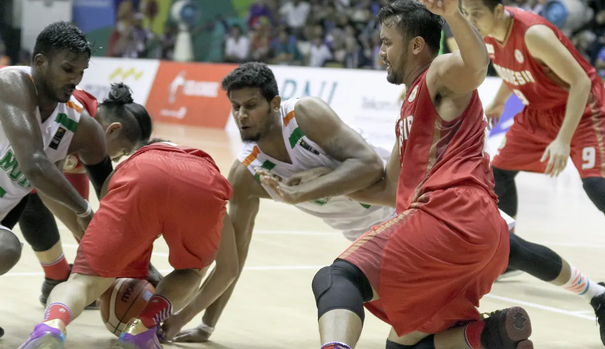 Perebutan bola terjadi antara kedua pemain Indonesia dan India pada final Invitation Tournament Asian Games 2018 di GBK Hall Basket, Jakarta. Indonesia menang 78-68 atas India. (Bola.com/Peksi Cahyo)