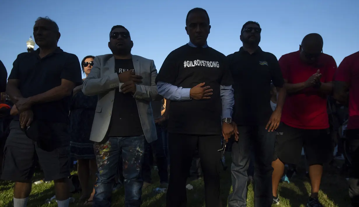 Anggota Dewan Kota Gilroy Fred Tovar (tengah) mengenakan baju #GILROYSTRONG saat menghadiri acara untuk korban penembakan brutal di festival kuliner Gilroy Garlic di Gilroy, California (29/7/2019). Dalam kejadian tersebut polisi berhasil menembak palaku penyerangan. (AP Photo/Noah Berger)