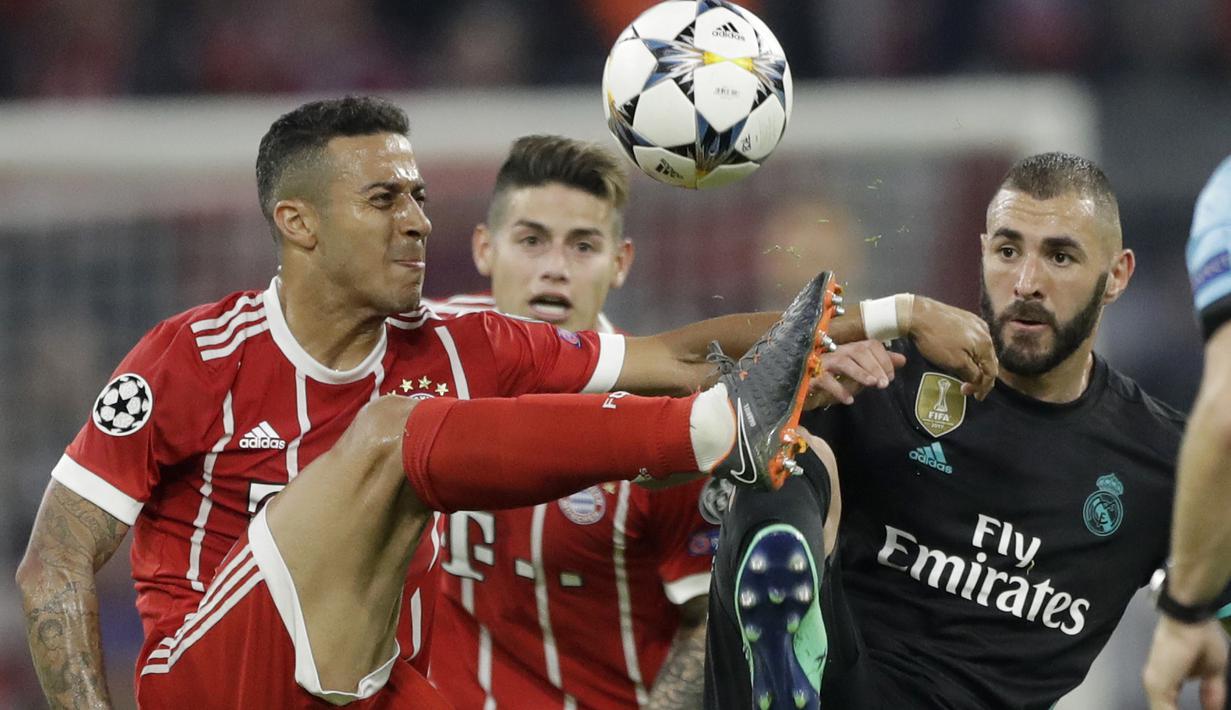 Duel pemain Bayern, Thiago (kiri) dan pemain Real Madrid, Karim Benzema  pada leg pertama semfinal Liga Champions di Allianz Arena, Munich, (25/4/2018). Real Madrid menang 2-1. (AP/Matthias Schrader)